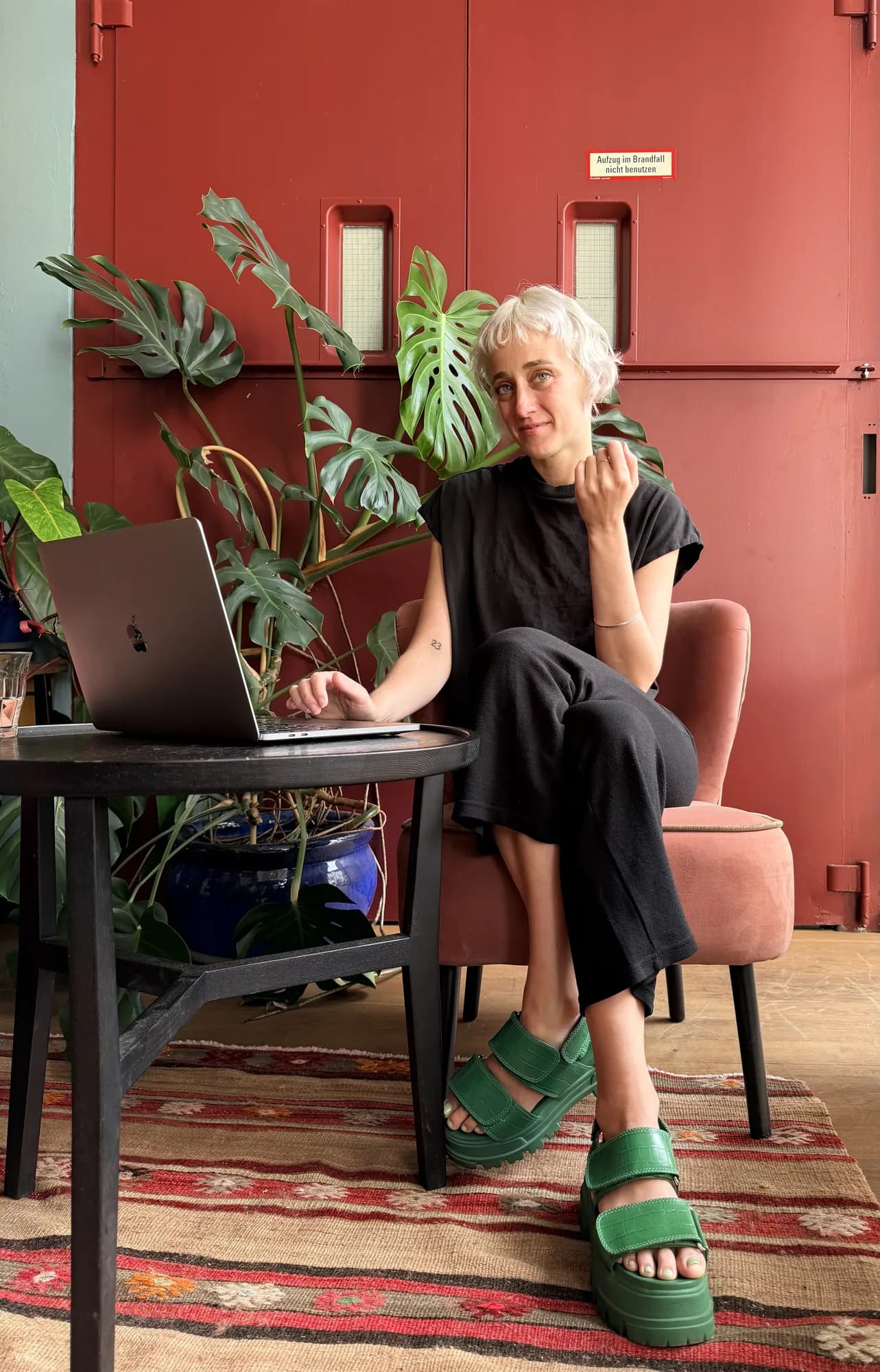 Amber Hoffman an ihrem Laptop, umgeben von Pflanzen